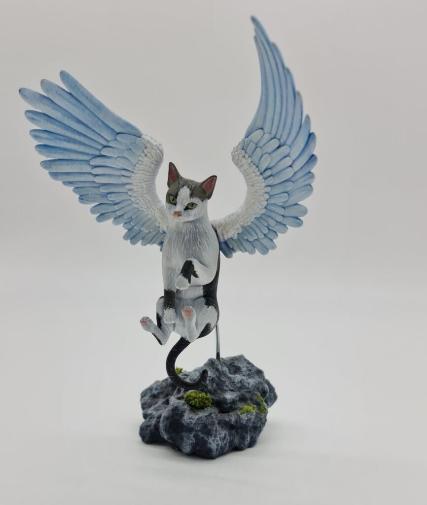 Gato con alas de ángel subiendo al cielo 